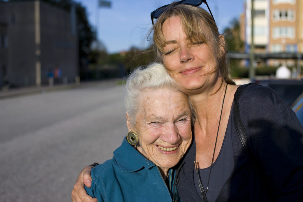 En yngre kvinna kramar om en äldre kvinna